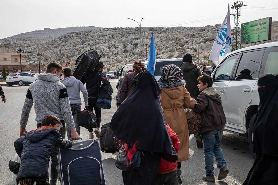 Uma família de refugiados sírios retorna ao norte da Síria vindo da Turquia, através da passagem fronteiriça de Bab al-Hawa.