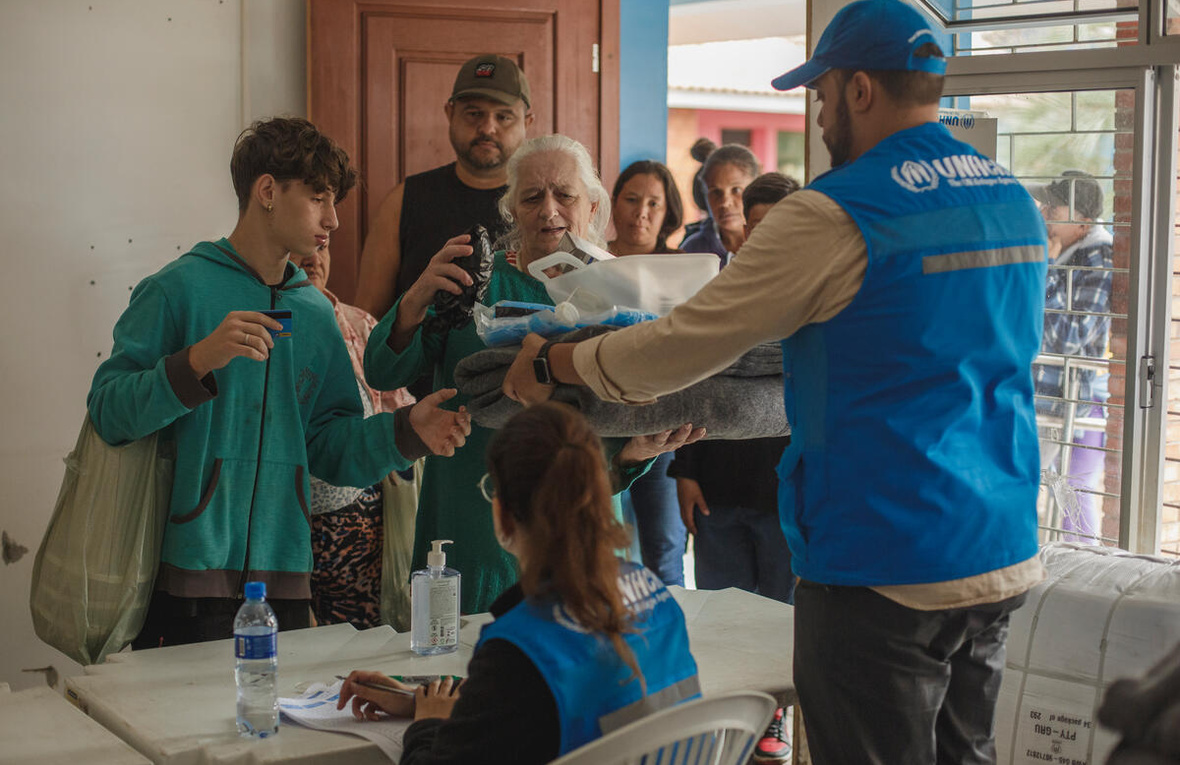 Gathered in a simple get-together, refugees living in the Sarandi neighborhood of Porto Alegre, the capital of Rio Grande do Sul, Brazil, interacted with Brazilian families from the same community. The event was a chance to thank the locals for their warm welcome, acknowledge the support they received during the floods between late April and early May 2024, and reaffirm their commitment to rebuilding their lives once again.The Brazilian and refugee families attending the event, held at the premises of Aldeias Infantis SOS, a UNHCR partner organization in Porto Alegre, had access to counseling services and were referred for documentation and social assistance according to their needs, with support from the Jesuit Service for Migrants and Refugees (SJMR), another UNHCR partner specializing in migration, forced displacement, and refuge. All participants received essential items donated by UNHCR to the Rio Grande do Sul state government, such as mosquito nets, solar lamps, and blankets.Rio Grande do Sul has a Brazil. Flood-affected Brazilians and refugees in Rio Grande do Sul celebrate World Refugee Day