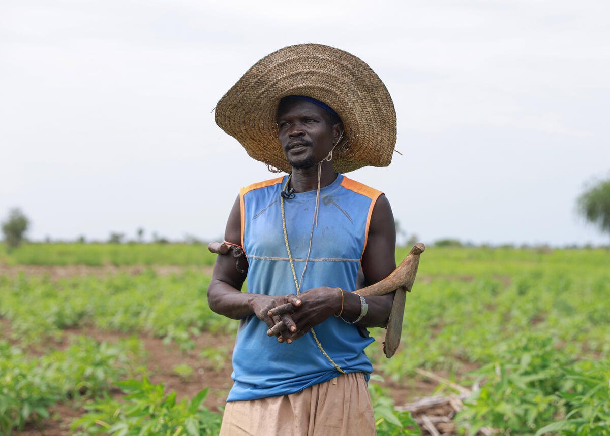 Un hombre con un gran sombrero de paja en un campo