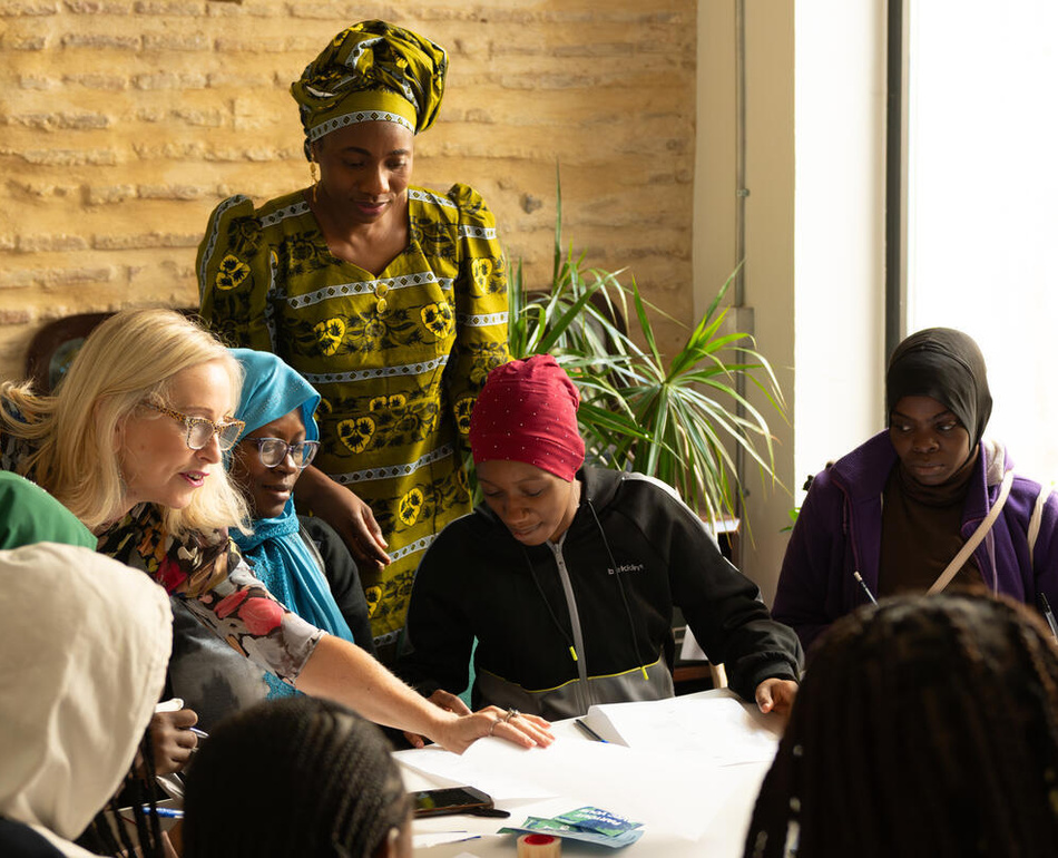 Aminata Soucko, a gender-based violence survivor from Mali in West Africa and the founder of the Red Aminata association, helps out with Spanish lessons for refugee women at the association’s office in Valencia, Spain, in October 2024. The classes, which are run with the support of UNHCR, aim to promote the inclusion of refugee women in Spain. Aminata Soucko asiste a las clases de español con voluntarias y alumnas en Red Aminata.