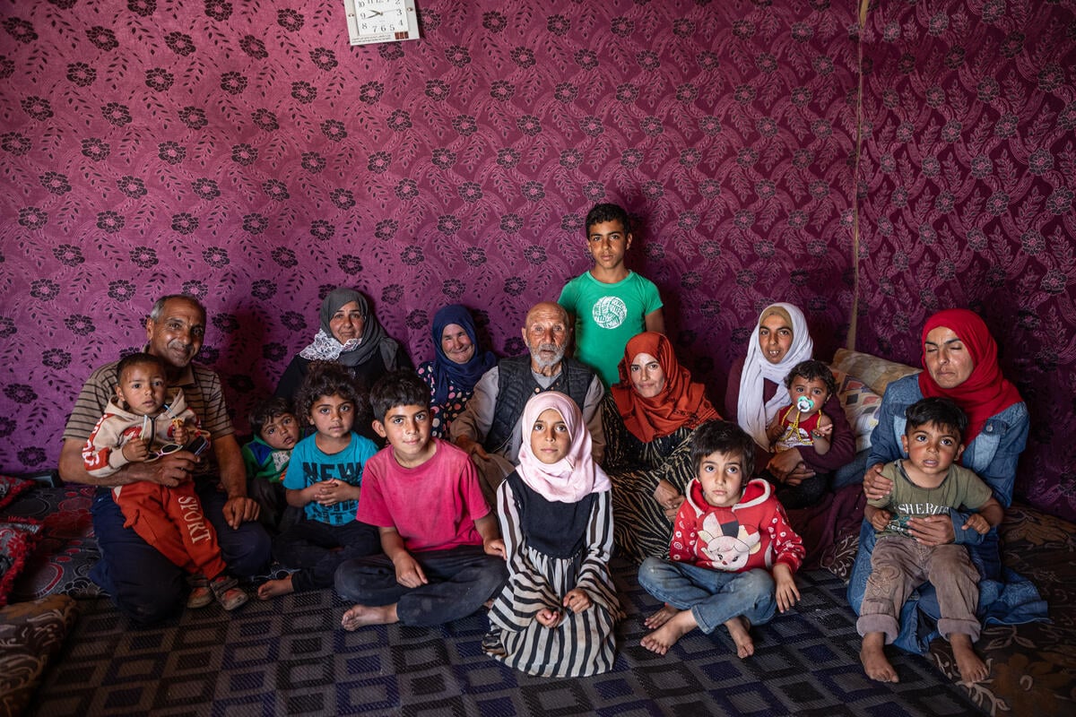 Jassim, (al centro) junto a varias generaciones de sus familiares en la tienda de campaña que han montado donde antes se encontraba su casa.