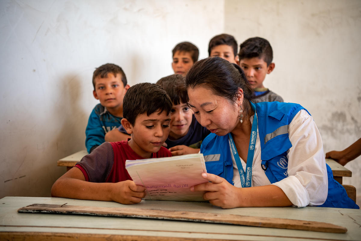 Integrante de ACNUR lee un libro con un niño, en Alepo, Siria. Integrante de ACNUR lee un libro con un niño, en Alepo, Siria.
