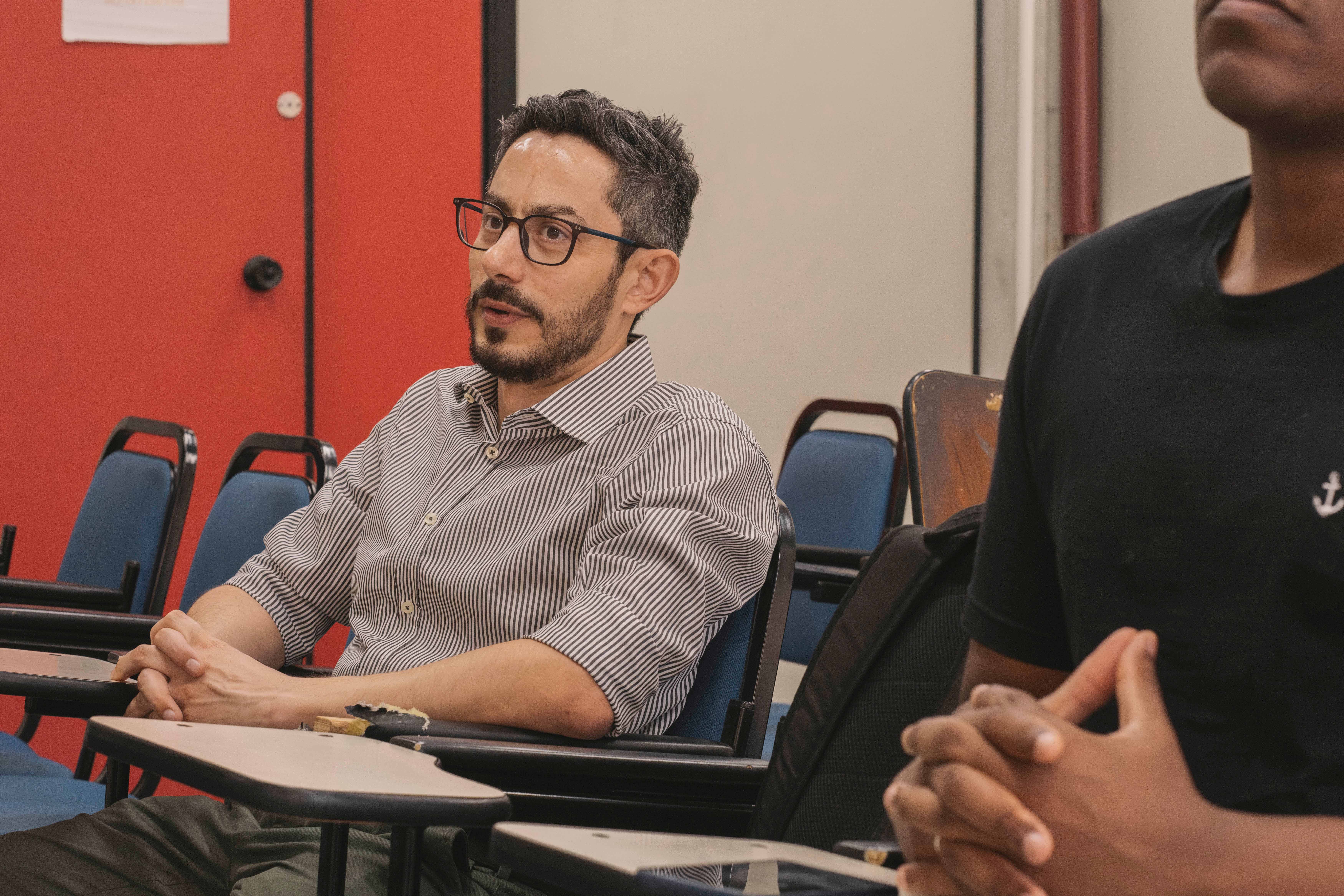 Un hombre con lentes en un salón de clase
