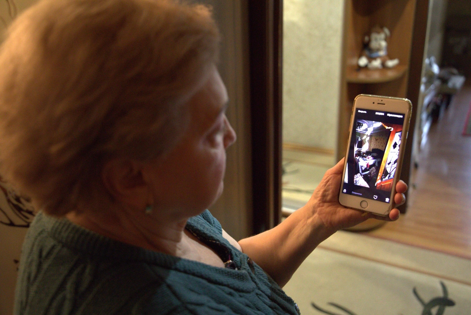 Una mujer mayor muestra una imagen en su teléfono móvil