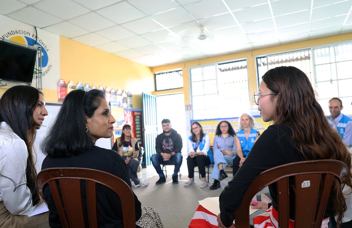 Un grupo de personas sentadas en círculo en una sala.