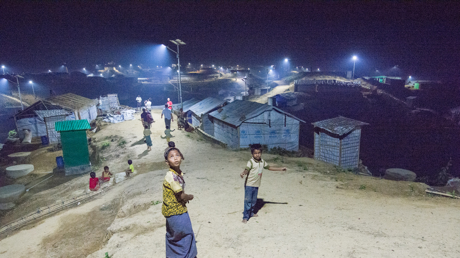Dos niños observan el alumbrado público en un campamento de refugiados